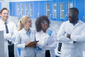 A group of scientists conversing in a lab.