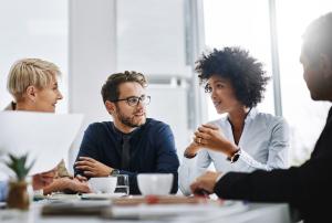 Four professionals talking over coffee.