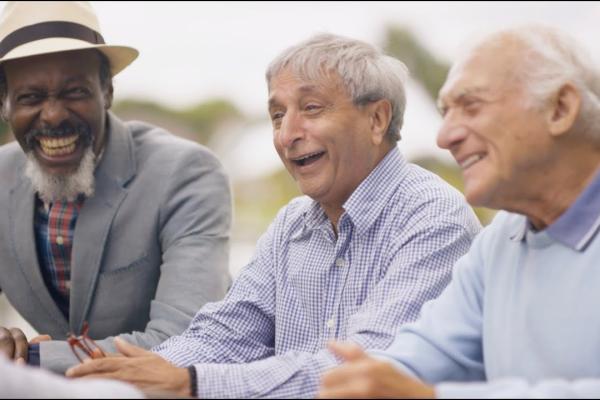 Three elderly men smiling and laughing.